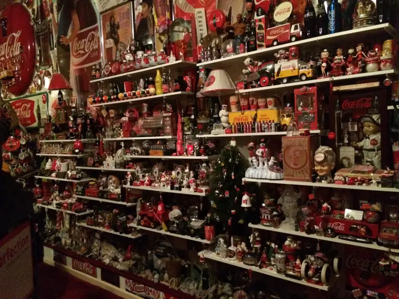 Shelves lined with Coca-Cola figurines, trucks, tins and holiday collectibles